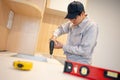Asian male furniture assembler installing kitchen counter