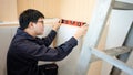 Asian male furniture assembler using spirit level tool Royalty Free Stock Photo
