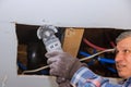 Maintenance repair works of replacement damaged drywall on worker cutting plasterboard with construction electric power tools