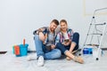 Home repair. Couple on break drinking coffee, taking a break from painting Royalty Free Stock Photo