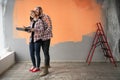 Home repair and decoration concept. Happy young loving couple planning home repair. Cheerful husband hugging his wife in Royalty Free Stock Photo