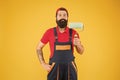 Home repair worker. bearded man worker with roller tool. hipster builder in cap yellow background. erector assistant in Royalty Free Stock Photo