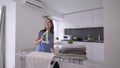 Home routines, cheerful housewife girl is ironing fresh towels and having fun and singing