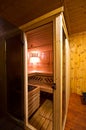 Sauna interior cabin detail with open door and lit lighting Royalty Free Stock Photo