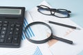 Home savings, budget concept. Chart ,glasses, pen, calculator and magnifying glass on wooden office table. Royalty Free Stock Photo