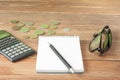 Home savings, budget concept. Model house, notepad, pen, calculator and coins on wooden office desk table. Royalty Free Stock Photo