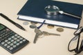 Home savings, budget concept. Model house, notepad, pen, calculator and coins on wooden office desk table. Royalty Free Stock Photo