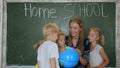 Home school concept. A mother gives her children a geography lesson with a globe in her hands. Royalty Free Stock Photo