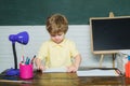 Home or school education. Portrait child from elementary school. Funny little kid pointing up on blackboard. Concept of