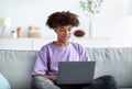 Home schooling. Black teenage guy having online class, using laptop, talking to fellow students or teacher