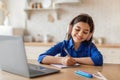 Cheerful girl studying online using laptop and headset indoor Royalty Free Stock Photo