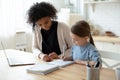 African tutor helps with school subject to little kid girl Royalty Free Stock Photo