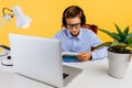 Home schooling and distance education for children. schoolboy sitting at a table reading a book, learning by video link with a Royalty Free Stock Photo