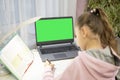 home-schooling. girl doing lessons in front of a laptop. back view. mockup Royalty Free Stock Photo