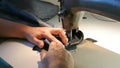 Home seamstress sews. Female hands sew jeans. A sewing machine works.