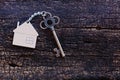 Home shape keyring with antique key on old wooden table. Welcome to new home, home sweet home concept. Copy space Royalty Free Stock Photo