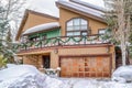 Home with snowy yard and driveway in front of front door and metal garage door