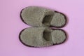 Home soft slippers made of sheep`s wool on a pink background Royalty Free Stock Photo