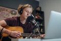 Home sound studio young teenager portrait playing guitar in Headphones recording voice music using a microphone and laptop Royalty Free Stock Photo