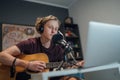 Home sound studio young teenager portrait playing guitar in Headphones recording voice music using a microphone and laptop Royalty Free Stock Photo