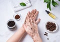 Home spa care for the skin of hands and nails. A young woman does a hand massage with a homemade coffee scrub with olive oil on Royalty Free Stock Photo