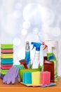 Home spring cleaning. Close-up of house cleaning products and cleaning supplies on orange wooden table over abstract bright Royalty Free Stock Photo