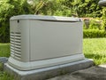 A Home Standby Generator installed at the backyard of a house. An air-cooled natural gas or liquid propane generator for