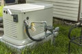 A Home Standby Generator installed at the backyard of a house. An air-cooled natural gas or liquid propane generator for