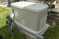 A Home Standby Generator installed at the backyard of a house. An air-cooled natural gas or liquid propane generator for