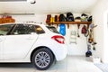 Home suburban car garage interior with wooden shelf , tools and equipment stuff storage warehouse on white wall indoors