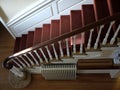 Home: sunlit staircase with red carpet