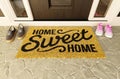 Home Sweet Home doormat with man and woman shoes on the porch at the front door Royalty Free Stock Photo