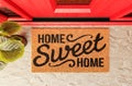 Home Sweet Home doormat on the porch at a red front door Royalty Free Stock Photo