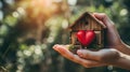 Home sweet home concept. Dream housing. Real estate. Hands holding miniature house with a red heart outdoors on a sunny summer day Royalty Free Stock Photo