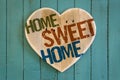 Home Sweet Home message wooden heart on turquoise painted background