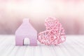 Home sweet home, miniature pink wooden house with design wooden heart over blurred pink background Royalty Free Stock Photo