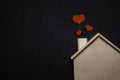 Home sweet home with red heart. Wooden house and Black leather background. Happy family lifestyles and Loving people concept.