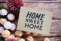 Home Sweet Home text message with flower decoration on wooden background