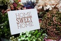 Home Sweet Home text message on paper card with beautiful flowers decoration