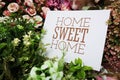 Home Sweet Home text message on paper card with beautiful flowers decoration