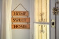 Home sweet home text on a wooden nameplate at the entrance to a house. Home decoration concept.