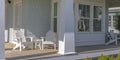 Home with tables and chairs on the sunlit porch