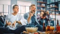 At Home Three Happy Ice Hockey Fans Sitting on a Couch Watch Game on TV, Celebrate Scoring, Sports Royalty Free Stock Photo