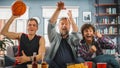 At Home Three Joyful Basketball Fans Sitting on a Couch Watch Basketball Game on TV, Celebrate