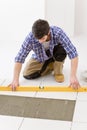 Home tile improvement - handyman with level Royalty Free Stock Photo