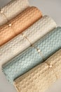 Home towels made of natural muslin in pastel shades are folded neatly in a row and decorated with a rope with a bead