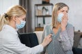 Home treatment of virus infection, coronavirus pandemic, Covid-19 outbreak. Female doctor during home visit examining Royalty Free Stock Photo