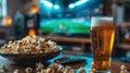 Home viewing of football match with beer, popcorn and remote control on table in front of modern TV and American football stadium