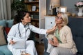 During a home visit to an elderly patient, a young endocrinologist doctor checks her thyroid gland by feeling her neck with her