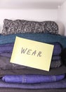 Home wardrobe with different items of clothing. Seasonal clothes sorting. Small space organization Royalty Free Stock Photo